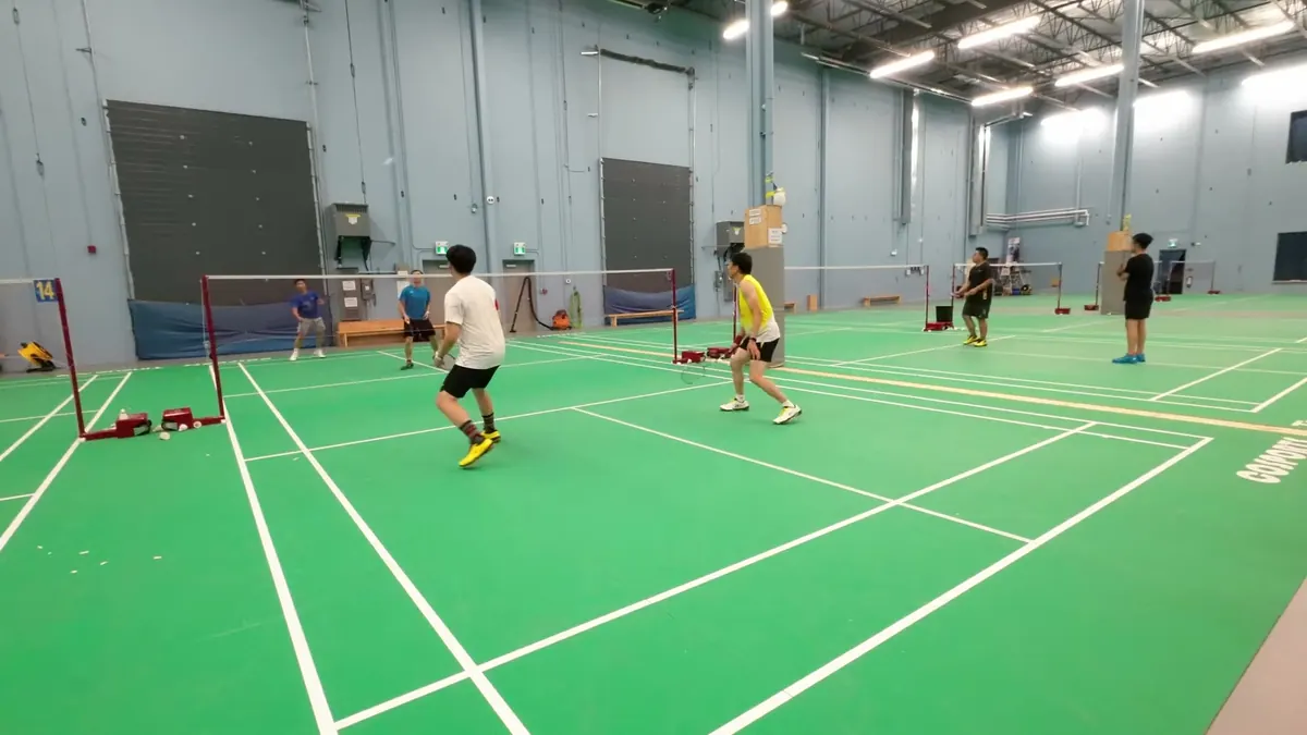 Good setup: a tripod at head height behind the baseline of a club court, with the court and players visible from end to end